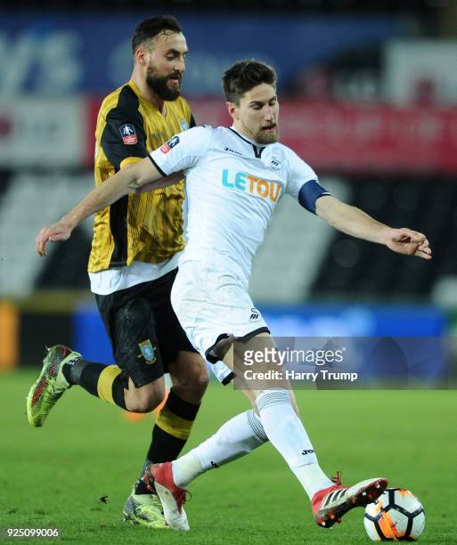 Federico Fernandez of Swansea City gets to the ball ahead of Atdhe Nuhiu of Sheffield Wednesday during the Emirates FA Cup Fifth Round Replay match...