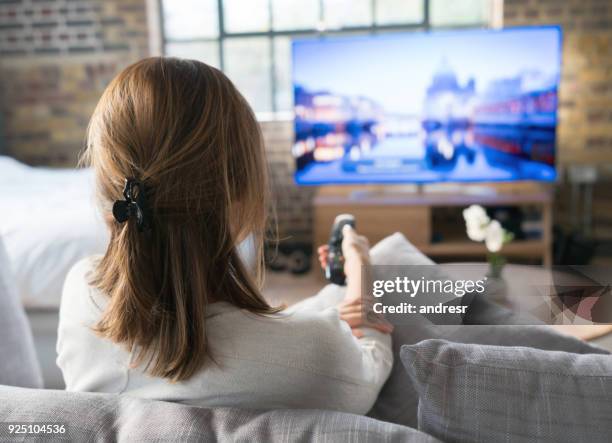 femme à regarder la télévision à la maison - regarder tv photos et images de collection