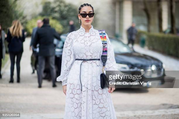 Guest wearing white dress with belt is seen outside Dior on February 27, 2018 in Paris, France.