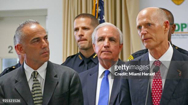 Florida Gov. Rick Scott, right, talks alongside Andrew Pollack, whose daughter Meadow was murdered in Parkland, and Miami-Dade County mayor Carlos A....