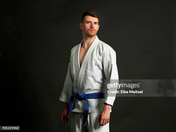 young man wearing a judo uniform looking at the camera - judo stock pictures, royalty-free photos & images