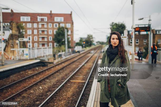 moe jonge vrouw te wachten voor het openbaar vervoer in londen, verenigd koninkrijk - parka coat stockfoto's en -beelden