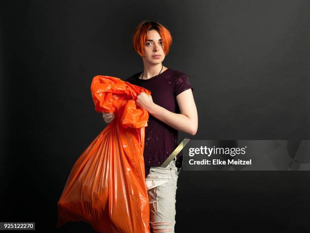young woman with orange garbage bag - white garbage bag stock pictures, royalty-free photos & images