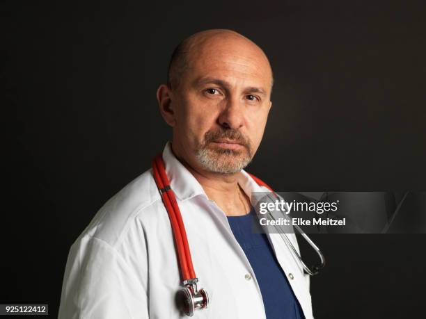 doctor with stethoscope looking at camera - determination doctor stock pictures, royalty-free photos & images