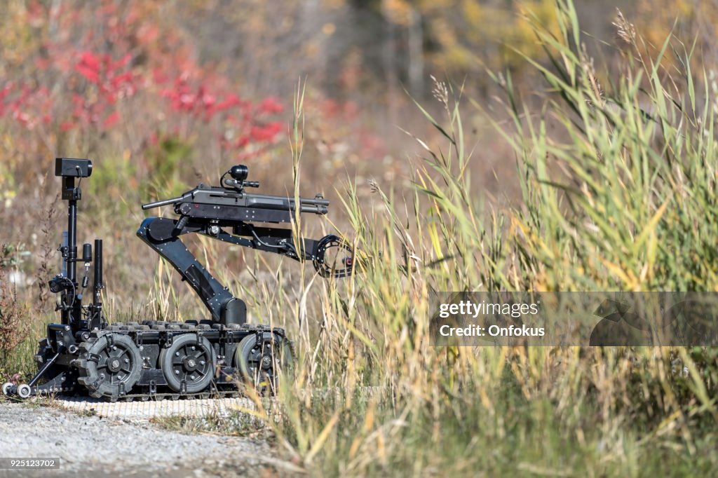 Policía Swat oficial utilizando una unidad de robots de brazo mecánico bomba eliminación