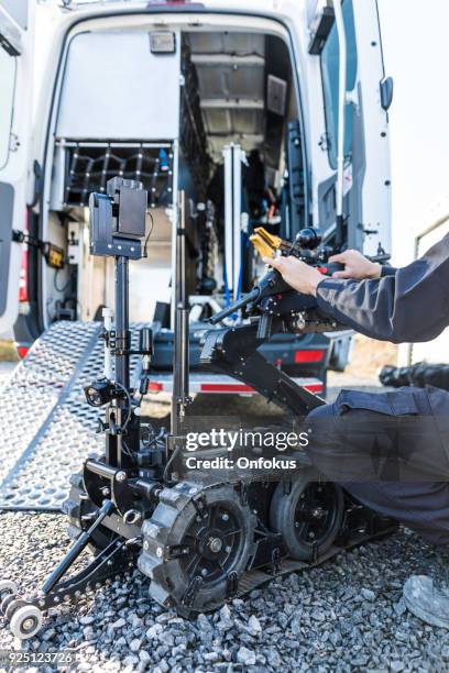 police swat officer using a mechanical arm bomb disposal robot unit - police van stock pictures, royalty-free photos & images