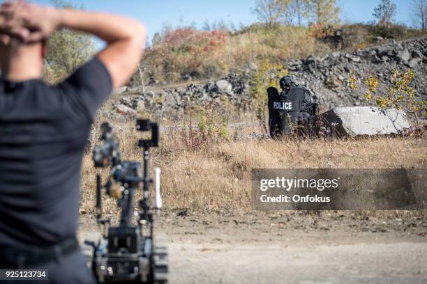 police swat team officers using a mechanical robot unit - bomb squad stock pictures, royalty-free photos & images