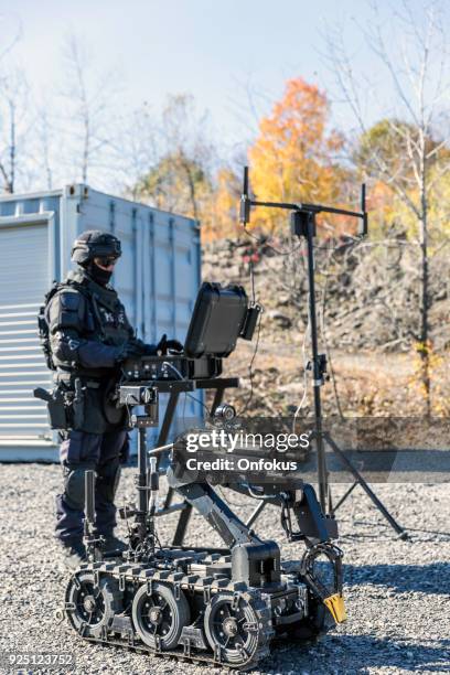 police swat officer using a mechanical arm bomb disposal robot unit - army navy game stock pictures, royalty-free photos & images
