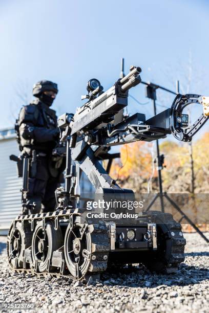 police swat officer using a mechanical arm bomb disposal robot unit - police van stock pictures, royalty-free photos & images