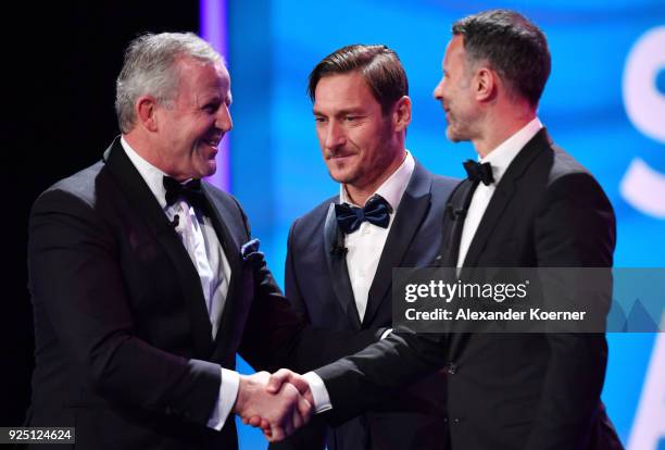 Laureus Academy Chairman Sean Fitzpatrick greets Francesco Totti and Ryans Giggs during the 2018 Laureus World Sports Awards show at Salle des...