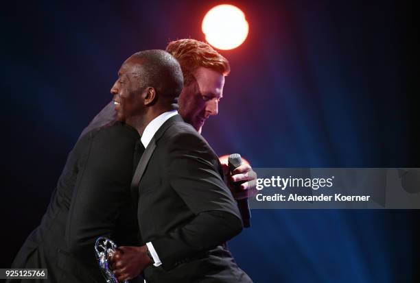 Laureus Academy member Michael Johnson greet J J Watt during the 2018 Laureus World Sports Awards show at Salle des Etoiles, Sporting Monte-Carlo on...