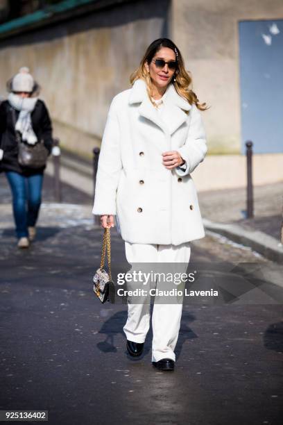 Guest wearing a white fur coat and a white pants is seen in the streets of Paris before the Dior show during Paris Fashion Week Womenswear...