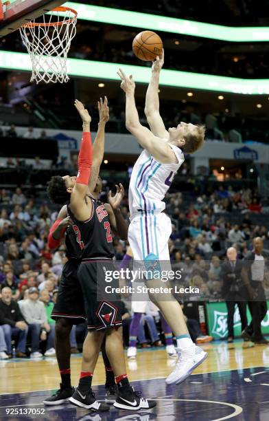 Cody Zeller of the Charlotte Hornets shoots over Cameron Payne of the Chicago Bulls during their game at Spectrum Center on February 27, 2018 in...
