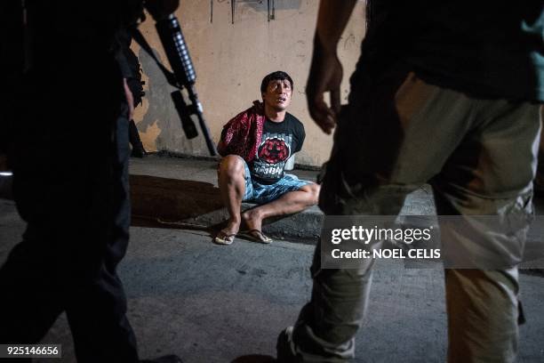 Philippine Drug Enforcement Agency agents and police arrest an alleged drug dealer during a drug raid in Maharlika Village, Taguig, south of Manila...