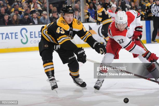 Danton Heinen of the Boston Bruins against Brett Pesce of the Carolina Hurricanes at the TD Garden on February 27, 2018 in Boston, Massachusetts.