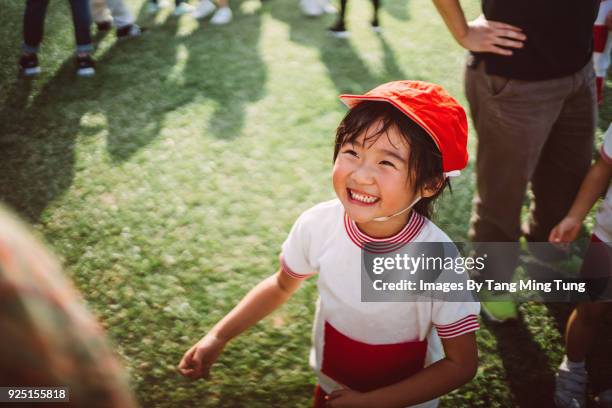 lovely little girl enjoying quality times with parents at school's sports day joyfully. - hong kong racing photos et images de collection