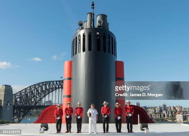 Captain Inger Klein Thorhauge with Cunard's famous Bellboys wearing R.M.Williams boots and Akubra hats in front of the funnel of Queen Elizabeth on...