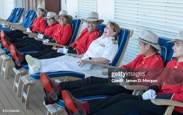 Captain Inger Klein Thorhauge with Cunard's famous Bellboys wearing R.M.Williams boots and Akubra hats on sunloungers on board Queen Elizabeth on...