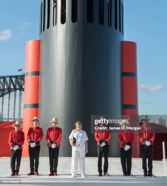 Captain Inger Klein Thorhauge with Cunard's famous Bellboys wearing R.M.Williams boots and Akubra hats in front of the funnel of Queen Elizabeth on...