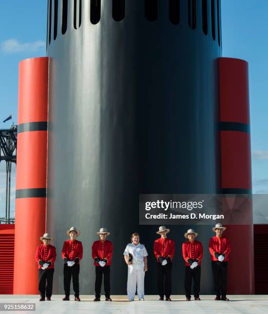 Captain Inger Klein Thorhauge with Cunard's famous Bellboys wearing R.M.Williams boots and Akubra hats in front of the funnel of Queen Elizabeth on...