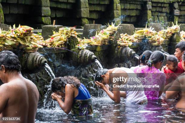 tourists bathing in the holy water at pura tirta empul temple, tampaksiring, bali, indonesia - tirta empul temple stock pictures, royalty-free photos & images