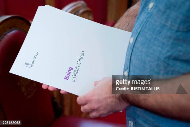 Man lays out "Being a British Citizen" information documents from the Home Office ahead of a citizenship ceremony at Islington Town Hall, in north...