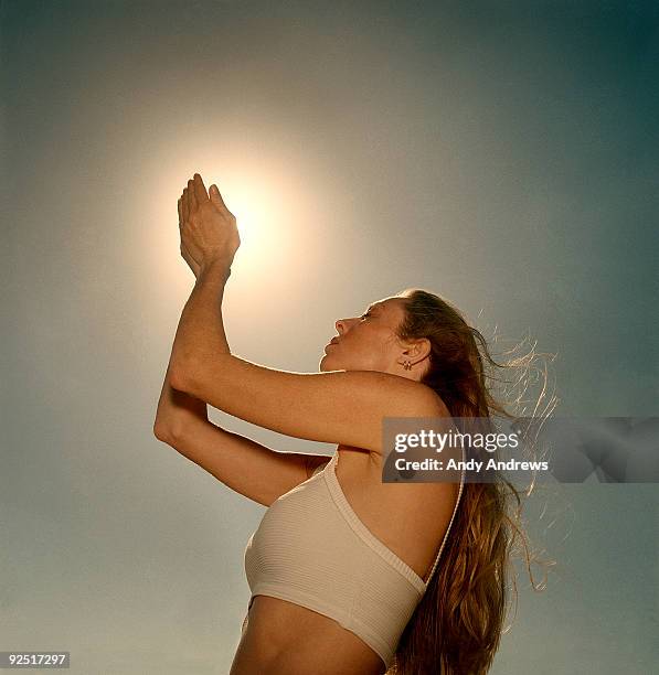 woman cupping the sun in her hands - andy andrews stock-fotos und bilder