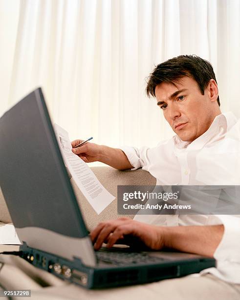 man working on laptop working from home - andy andrews stock-fotos und bilder