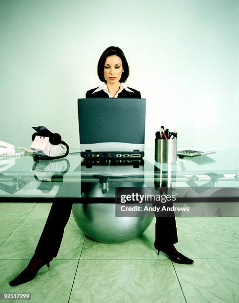 woman at desk working on laptop - andy andrews stock-fotos und bilder