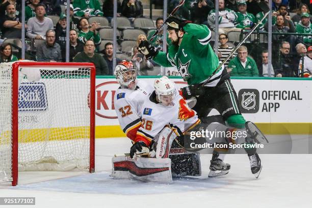 Dallas Stars left wing Jamie Benn crashes into Calgary Flames defenseman Michael Stone and goaltender Jon Gillies during the game between the Dallas...