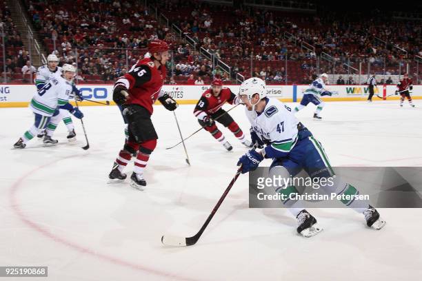 Sven Baertschi of the Vancouver Canucks skates with the puck ahead of Josh Archibald of the Arizona Coyotes during the first period of the NHL game...