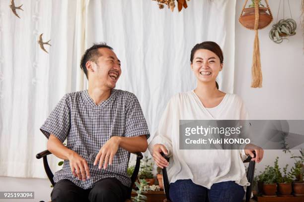 una coppia seduta su una sedia con un sorriso. - the japanese wife foto e immagini stock
