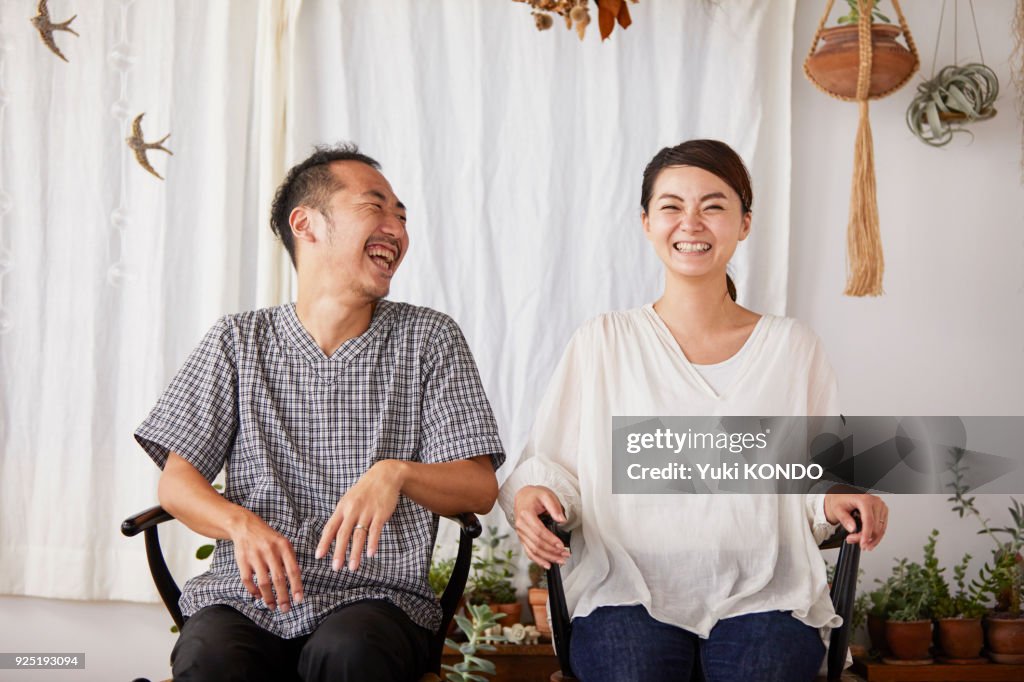 A couple sitting in a chair with a smile.