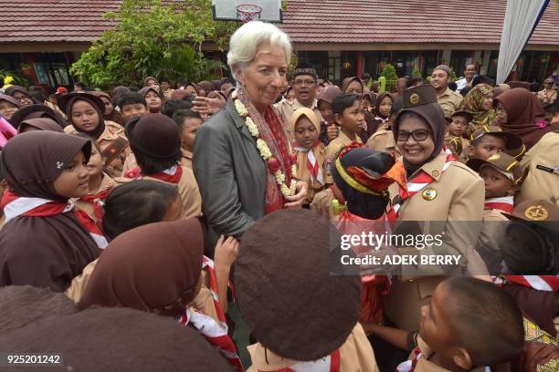 Managing Director of the International Monetary Fund Christine Lagarde greets schoolchildren during a visit in Cilincing, Jakarta on February 28,...