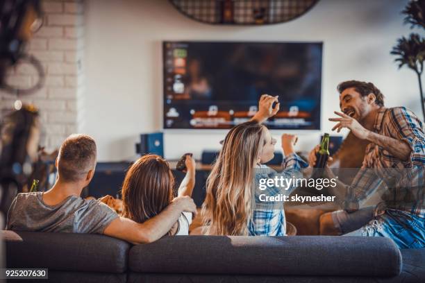 grupo de personas felices gastando su tiempo en la sala de estar. - man living room fotografías e imágenes de stock