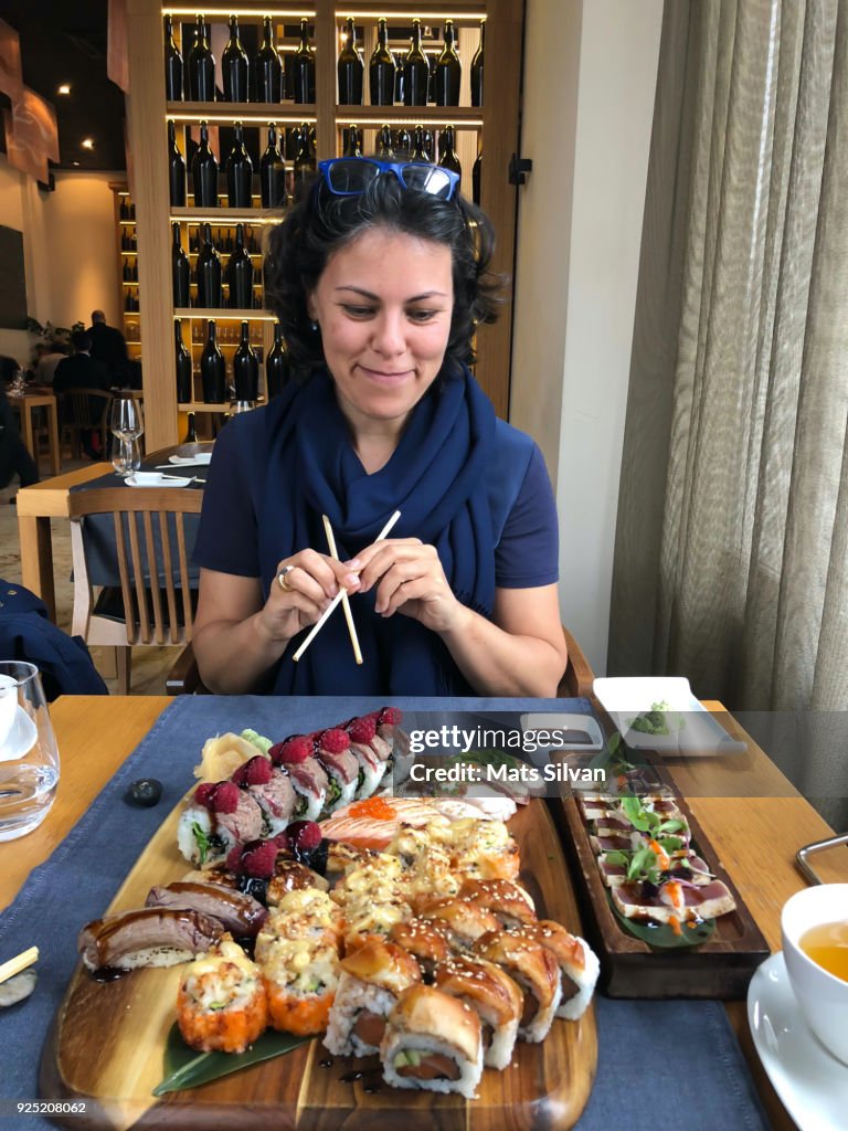 Happy Woman Eating in a Japanese Restaurant
