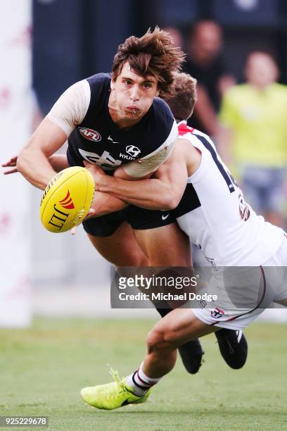 Caleb Marchbank of the Blues handballs from Jack Lonie of the Saints during the JLT Community Series AFL match between the Carlton Blues and the St...
