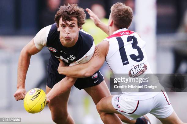 Caleb Marchbank of the Blues handballs from Jack Lonie of the Saints during the JLT Community Series AFL match between the Carlton Blues and the St...