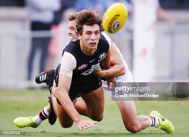 Caleb Marchbank of the Blues is tackled by Jack Lonie of the Saints during the JLT Community Series AFL match between the Carlton Blues and the St...