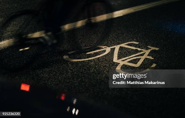 urban city street night lights szene with reflection and a bicycle - matthias makarinus stock-fotos und bilder