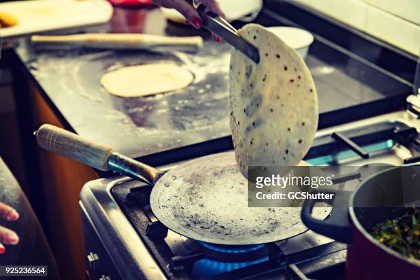 using tongs to lift a ready chapati - roti stock pictures, royalty-free photos & images