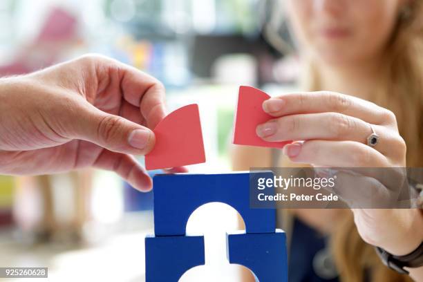 adults playing with building blocks in office - business relationship stock pictures, royalty-free photos & images