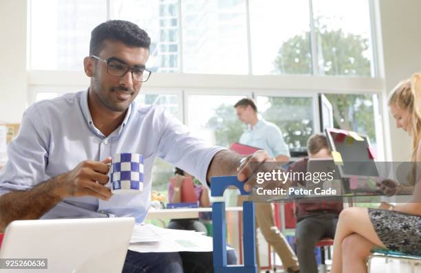 man in office playing with building blocks - unproductive employee stock pictures, royalty-free photos & images