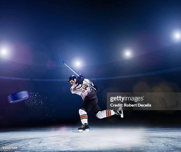 ice hockey player shooting puck. - hockey rink stock-fotos und bilder