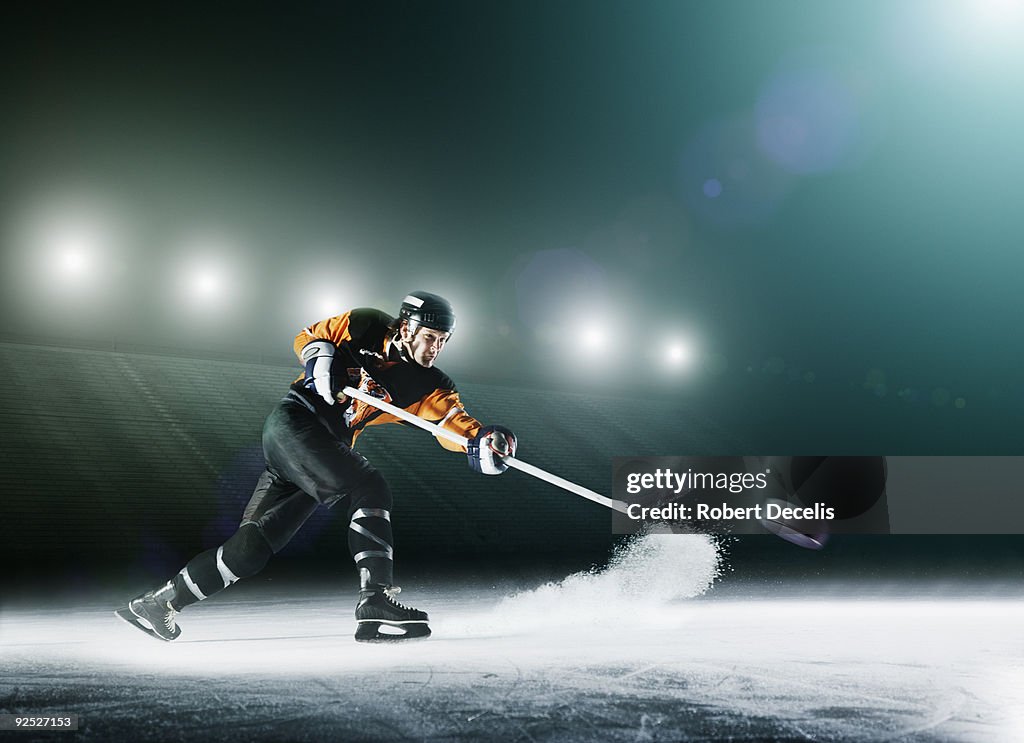 Ice hockey player passing puck.