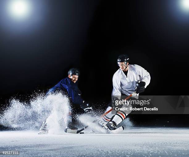 two ice hockey players challenging for the puck. - ice hockey stock pictures, royalty-free photos & images