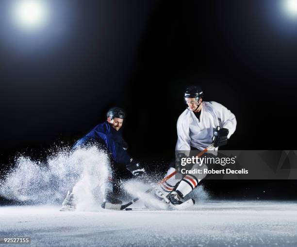 two ice hockey players challenging for the puck. - hockey rink stock pictures, royalty-free photos & images