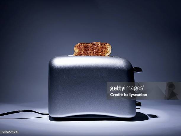 silver colored toaster with single slice of toast. - toaster fotografías e imágenes de stock