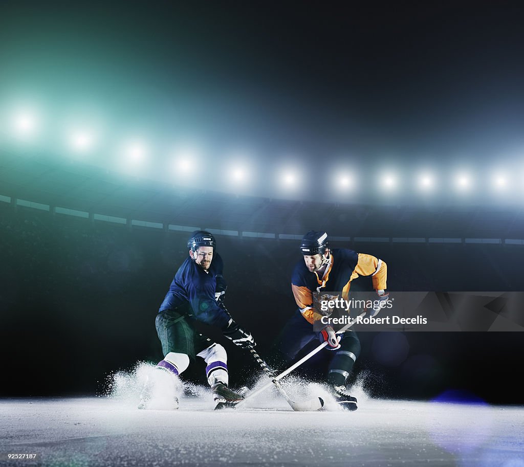 Two ice hockey players competing for puck.