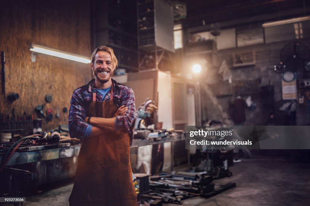 Glücklich professionelle Handwerker stehen in Werkstatt mit Werkzeugen